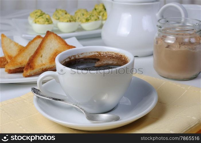 Cup coffee with toast and a jar of paste, stuffed eggs