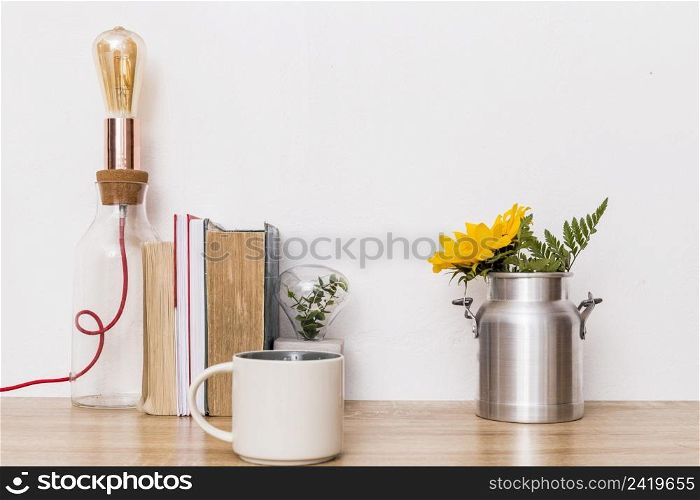 cup flowers tin can books lamp table