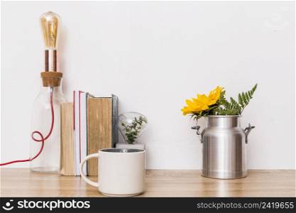 cup flowers tin can books lamp table