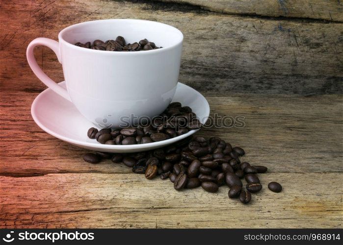 Cup full of coffee beans on wood