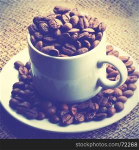 Cup full of coffee beans. Retro style filtred image
