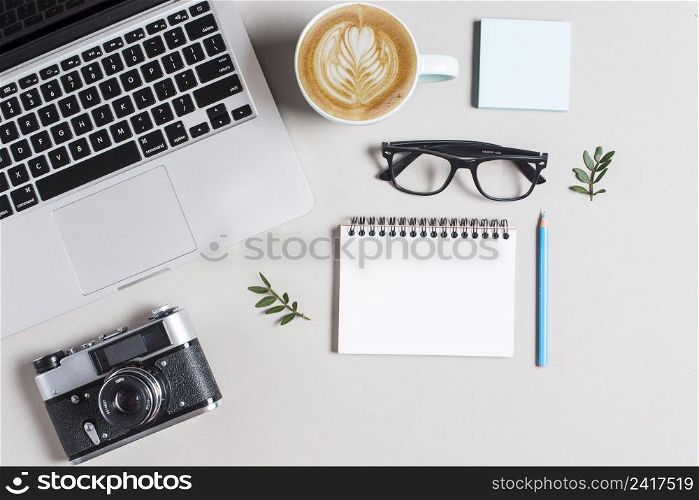 cup hot coffee cappuccino latte art laptop camera with stationeries white background