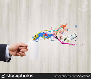 Cup in hand. Close up of businessman holding white cup with icons flying out