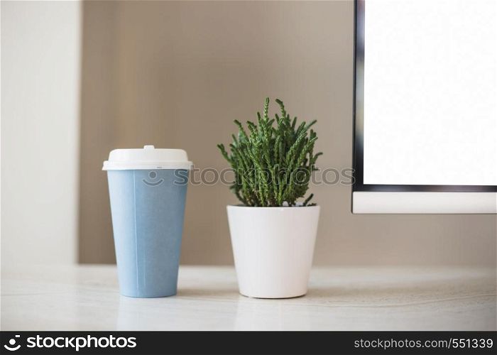 cup near plant pot near tv