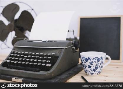 cup near retro typewriter