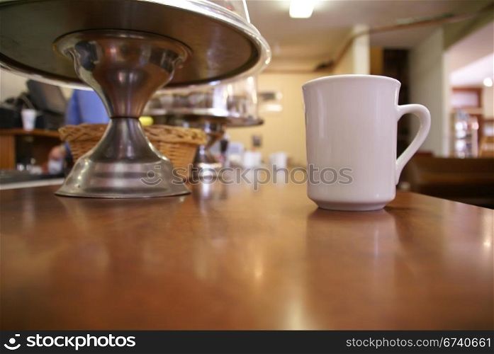 Cup o&rsquo; Joe - coffee cup at cafe counter, with doughnut holder, Banff, Alberta, Canada