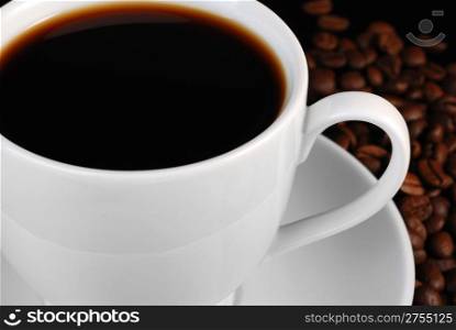 Cup of black coffee. A background with coffee grains and a white cup. A photo close up
