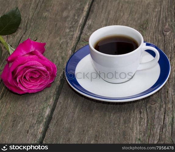 cup of black coffee and rose on the old desktop