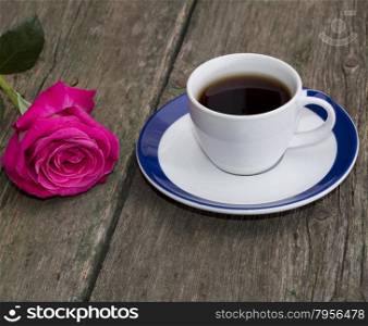 cup of black coffee and rose on the old desktop