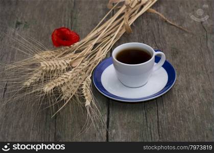 cup of black coffee, bunch of wheaten ears and flower of poppy, still life, subject beautiful flowers and drinks