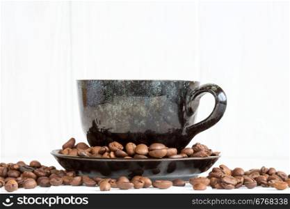 Cup of black coffee on a white background with coffee beans