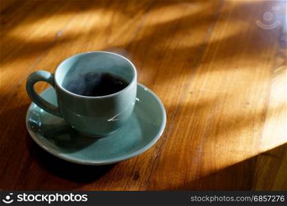 cup of black coffee on wooden table