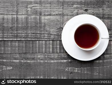 Cup of black healthy tea on wooden background