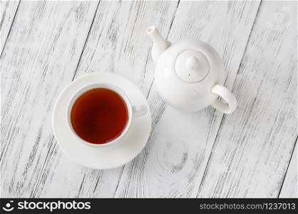 Cup of black tea on wooden background