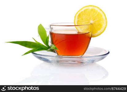 Cup of black tea with lemon and green leaves isolated on white background