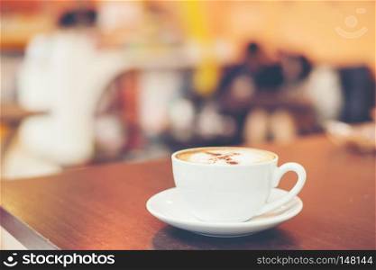 Cup of cappuccino at coffee shop background.