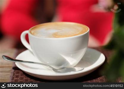 Cup of cappuccino in outdoor cafe, selective focus