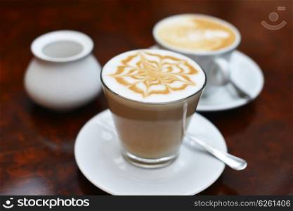 cup of cappuccino with brown and white foam on top