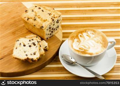 cup of cappucino and cakes on wooden background