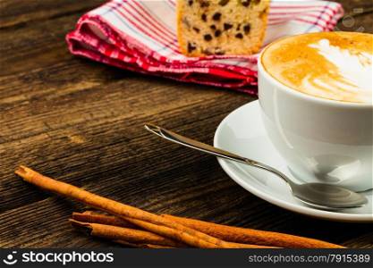 cup of cappucino, cinnamon stick and coffee bean isolatad on wooden background
