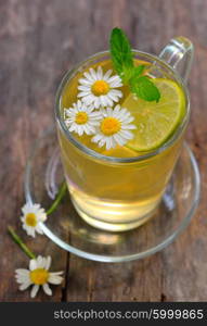 cup of chamomile tea with chamomile flowers