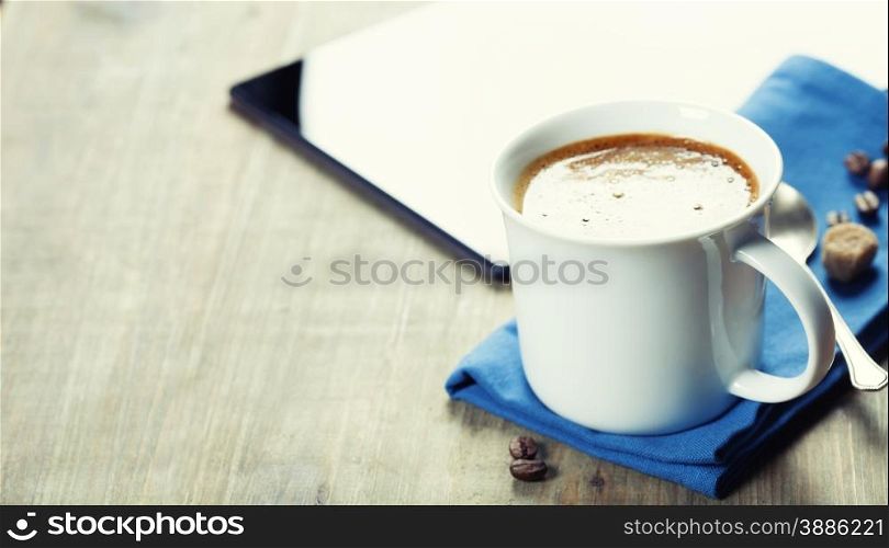 Cup of coffe with Digital tablet computer and smart phone on wooden table. Modern life and Business concept.