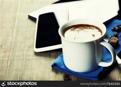Cup of coffe with Digital tablet computer and smart phone on wooden table. Modern life and Business concept.