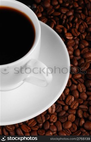 Cup of coffee. A background with coffee grains and a white cup. A photo close up