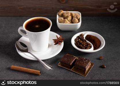 Cup of coffee and beans on table background. Set of coffee and sweets with food ingredient