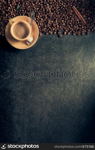 cup of coffee and beans on table background, top view