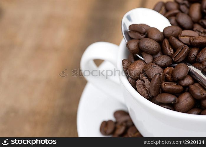 Cup of coffee and beans on wooden background