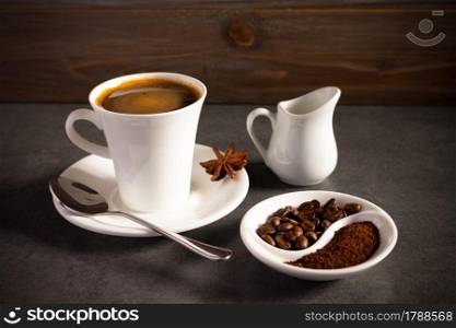 Cup of coffee and beans with ingredient on table background texture. Abstract concept of break coffee time