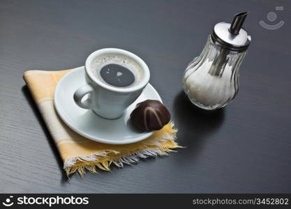 cup of coffee and chocolate candy on table