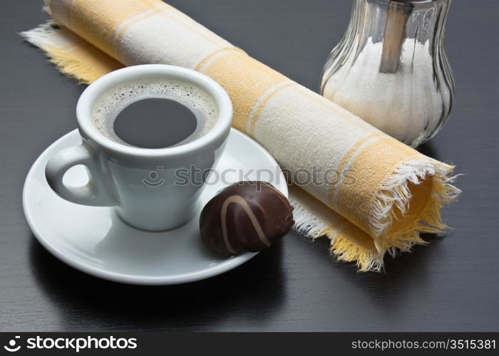 cup of coffee and chocolate candy on table