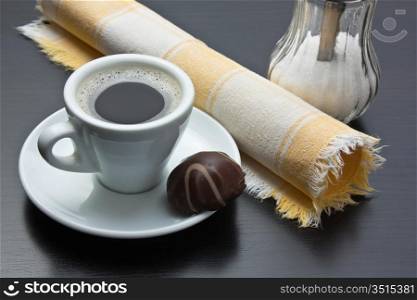 cup of coffee and chocolate candy on table