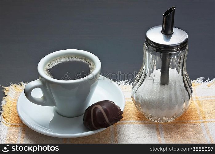 cup of coffee and chocolate candy on table