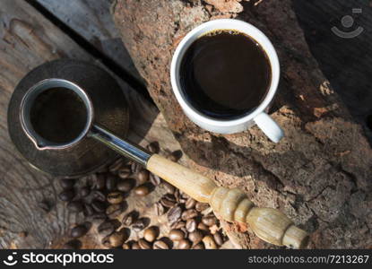 Cup of coffee and coffee beans on a stone background.. Cup of coffee and coffee beans on a stone background