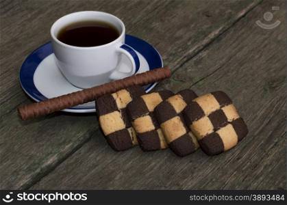 cup of coffee and cookies in a row on an old table