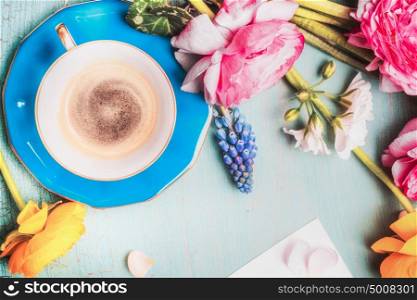 Cup of coffee and flowers on blue vintage shabby chic background, top view, copy space. Summer Breakfast