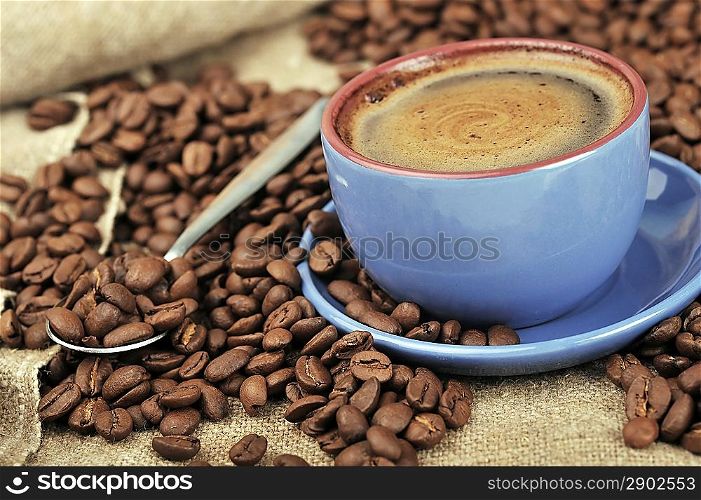 Cup of coffee and spilled out coffee beans