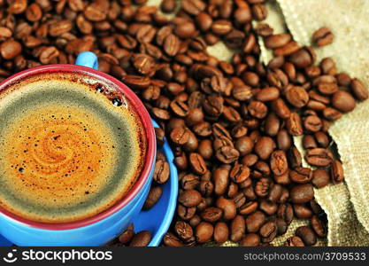 Cup of coffee and spilled out coffee beans