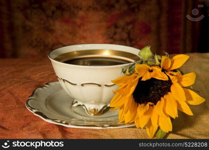 cup of coffee and sunflower colored background