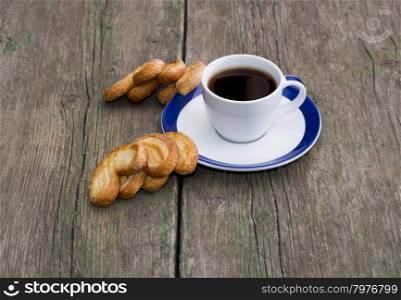 cup of coffee and two groups of cookies on a wooden table, a still life on a subject food and drinks