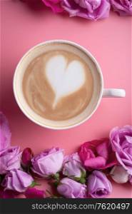 cup of coffee around may roses against pink background. romantic and beauty concept