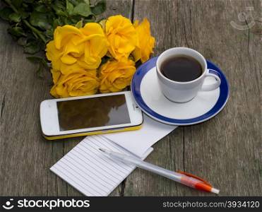 cup of coffee, bouquet of yellow roses, phone, the handle, the top view, on a wooden table, a still life, a subject beautiful flowers and drinks