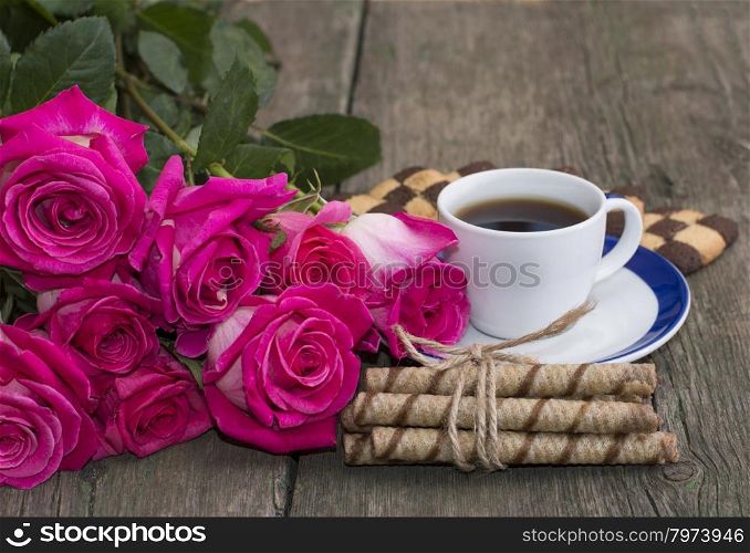 cup of coffee, cookies and bouquet of scarlet red roses