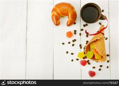 Cup of coffee, croissant, waffles and marmalade on wood white background. Free space for text.