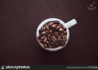 Cup of coffee full of coffee beans.. Cup of coffee full of coffee beans