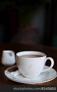 cup of coffee on a table, vintage color photograph, film noise and grain in the photograph. Vertical frame, selective focus, blurred background. Idea for screensaver or menu, articles about coffee