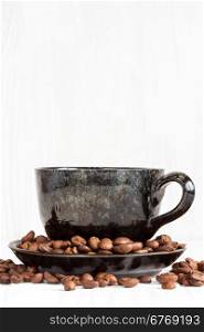 Cup of coffee on a white wood background with coffee beans
